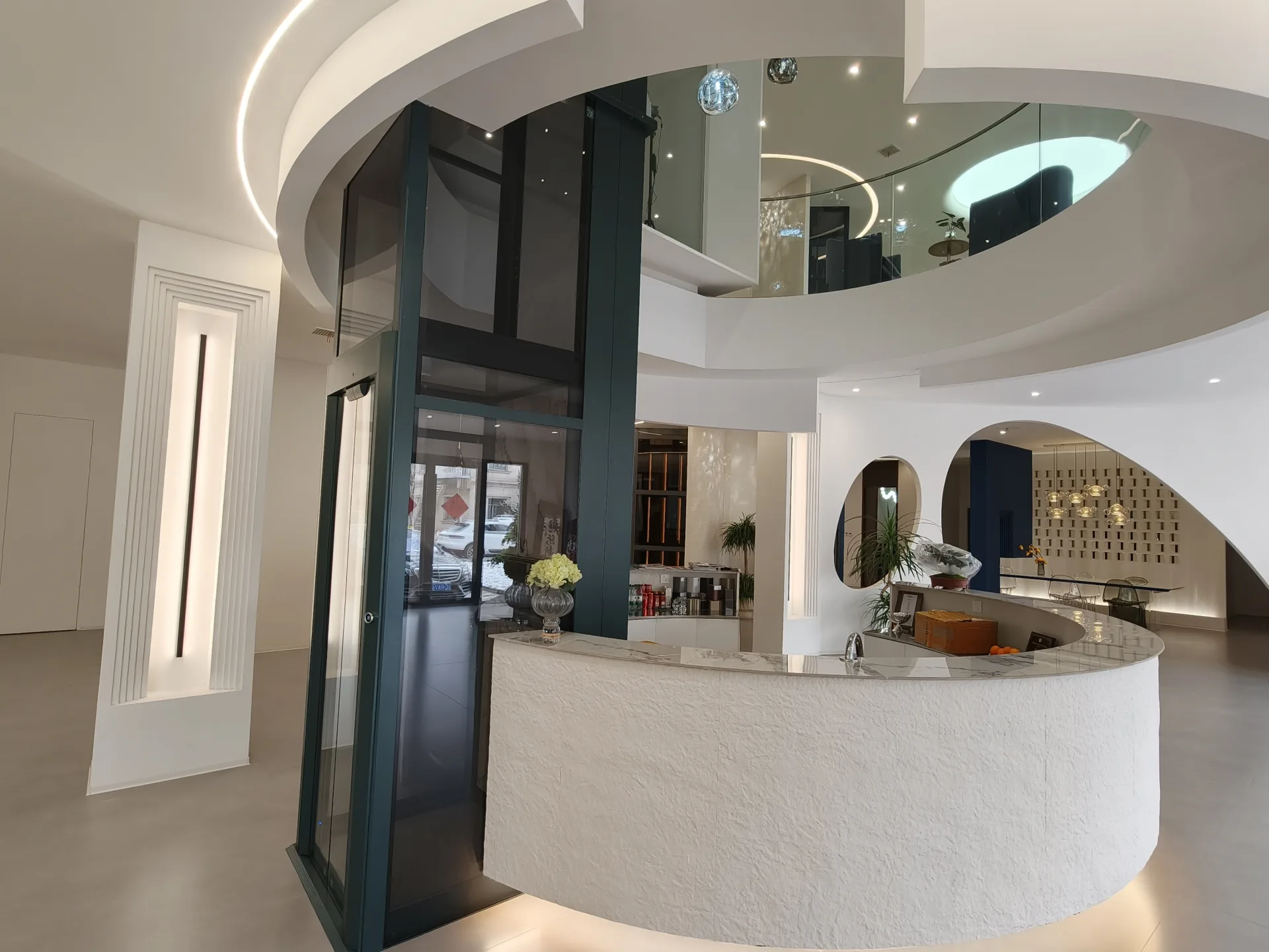Glass home elevator beside the curved reception counter in JAFITA Beijing showroom