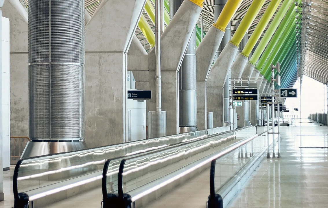 Horizontal moving walk with glass balustrades inside an airport terminal