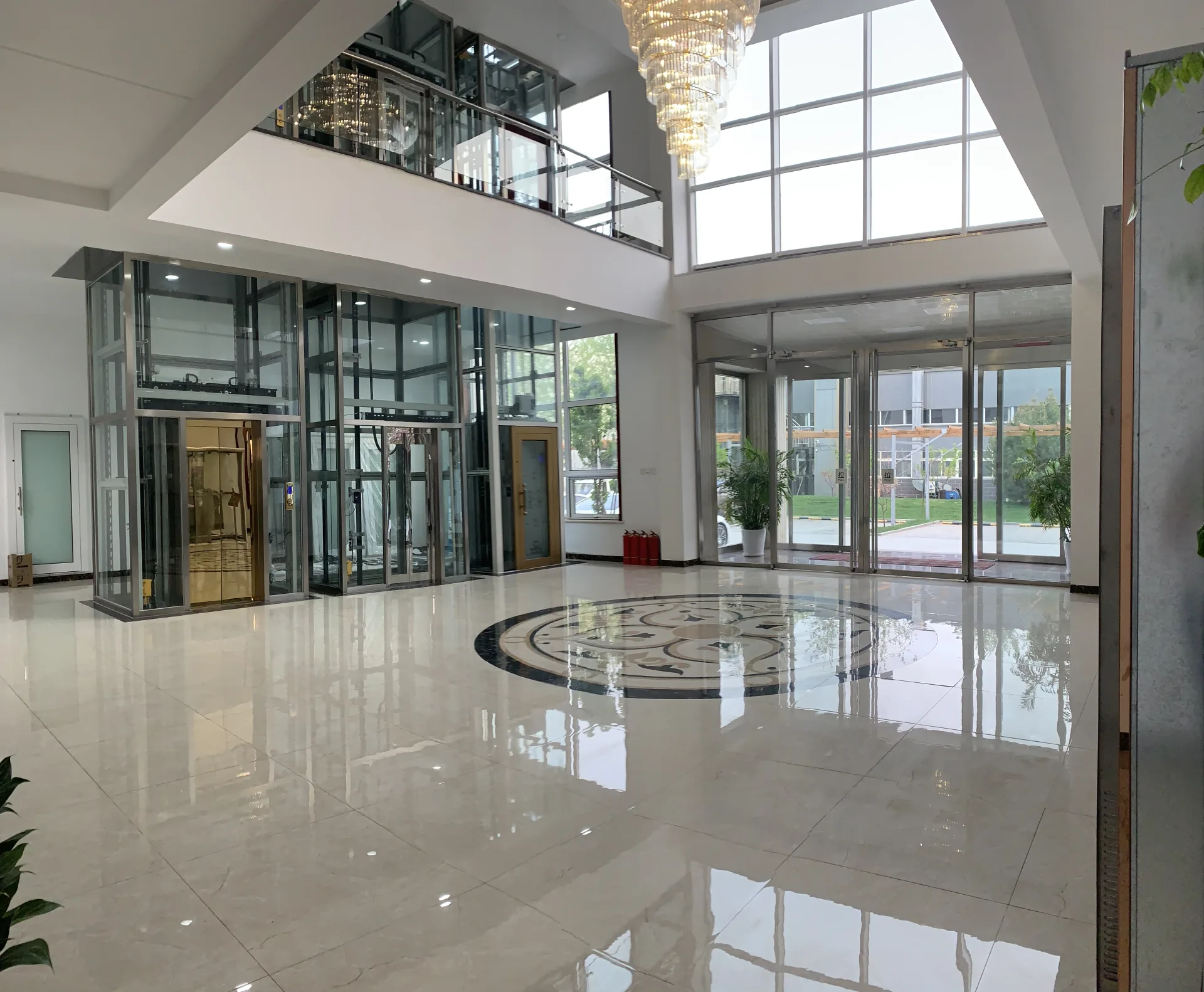 Glazed elevator tower and surrounding structure in a two-level JAFITA showroom atrium