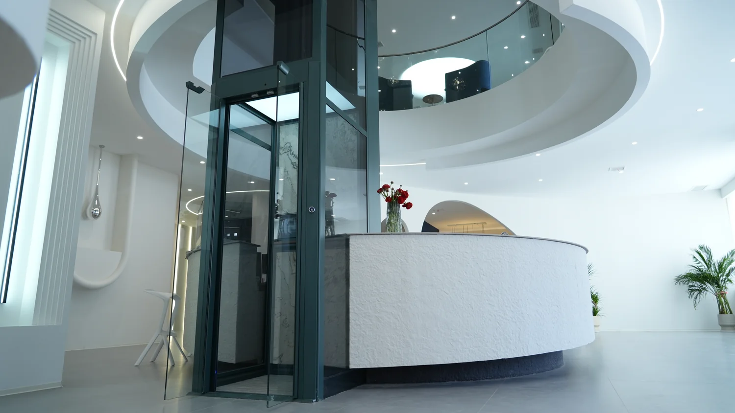 Glazed home elevator beside a curved counter in the Beijing showroom
