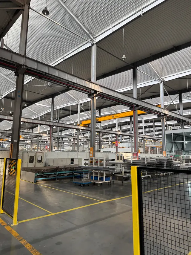 Production equipment and overhead cranes inside a manufacturing workshop
