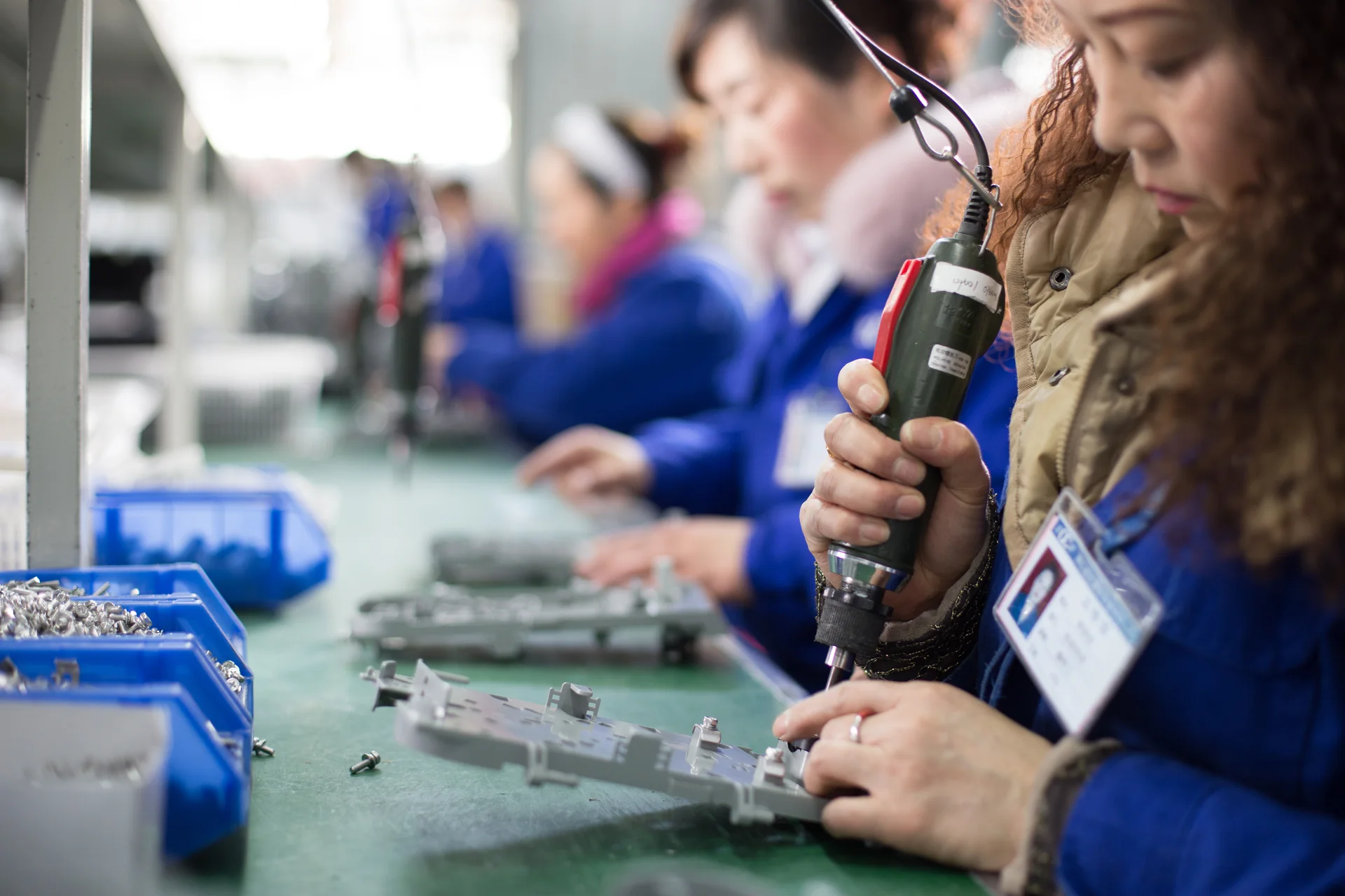 Technicians assembling electronic components at a workbench