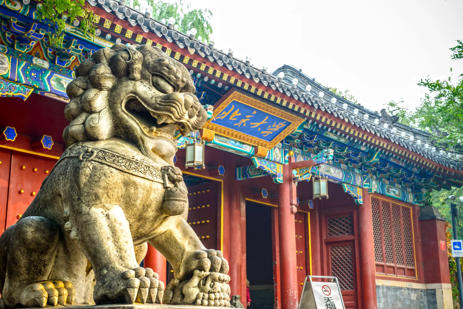 Peking University gate sign beside a stone lion from the company brochure image archive