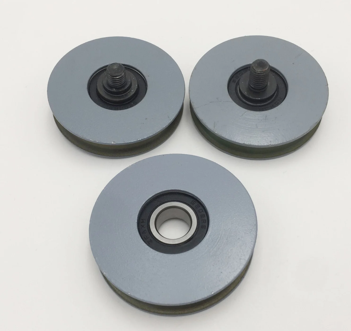 Three grey door rollers with bearings and threaded mounting studs