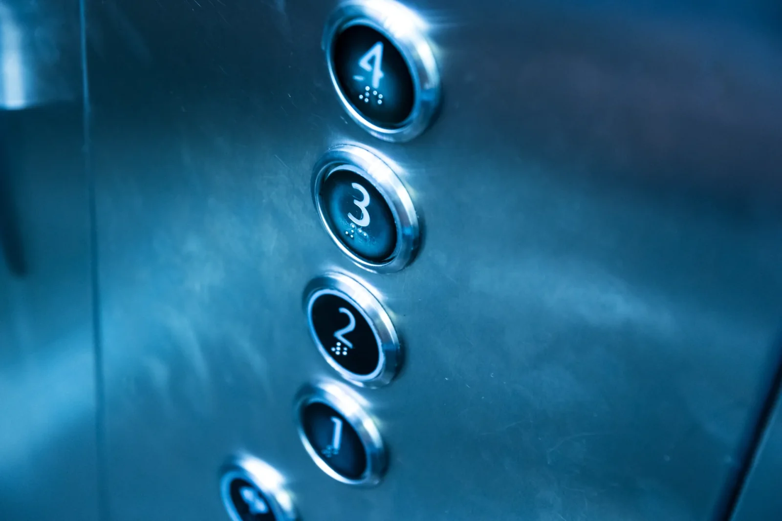 Close-up of illuminated round elevator floor buttons