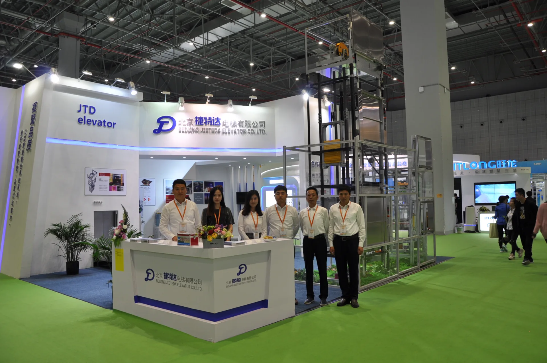 The exhibition team standing beside the reception counter at the Jieteda booth.